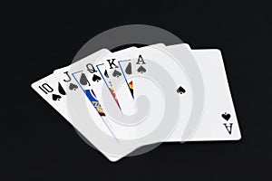 Royal Flush of spades in poker cards game on a black background