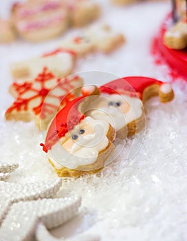 Royal icing decorated Christmas cookies on artificial snow; Christmas/winter background