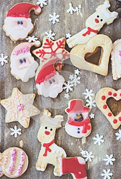 Royal icing decorated christmas cookies on wooden background;