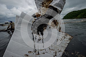 Royal Thai Navy and local volunteers cleaning up a beach from a oil slick on Ao Phrao beach on Samed Island, rayong, Thailand. An