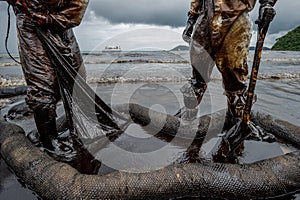 Royal Thai Navy and local volunteers cleaning up a beach from a oil slick on Ao Phrao beach on Samed Island, rayong, Thailand. An