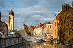 Rozenhoedkaai canal reflection at sunrise and blurred clouds, Bruges