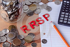 `RRSP` Registered Retirement Savings Plan signs with coins in the background