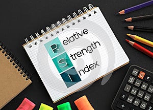 RSI - Relative Strength Index acronym on notepad, business concept background