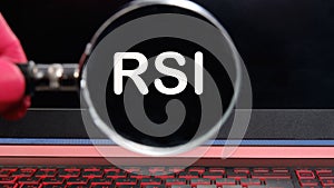 RSI Relative Strength Index text on the monitor found through a magnifying glass