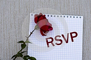 RSYP - words on a white sheet of paper with a red rose on a gray background