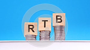 rtb - text on wood cube block stack with coins