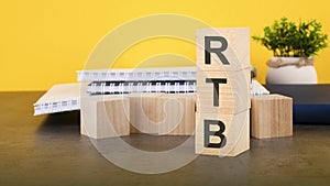 RTB - text on wood cubes stack, yellow background