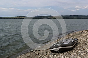 A rubber boat stands on the bank of the river.A means of transportation on the water