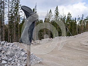 Rubber boot on a stick, bad road signpost
