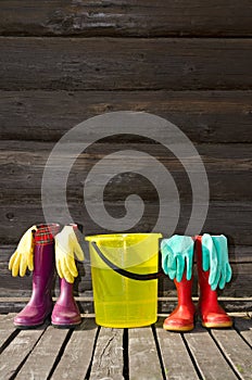 Rubber boots, bucket and gloves on veranda