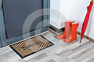 Rubber boots, umbrella and mat near door