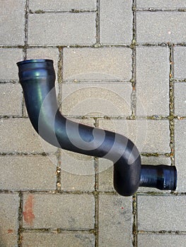 Rubber car hose, black color, concrete pavement background