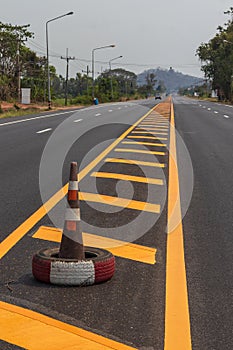 Rubber cone and yellow line strip on the road