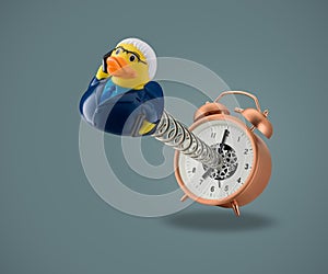 Rubber duck business man coming out of alarm clock