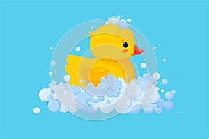 Rubber duck in soap foam with bubbles isolated in blue background. Side view of yellow plastic duckling toy in suds