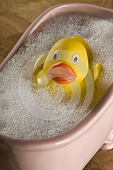 Rubber ducky in small pink porcelain bubble bath