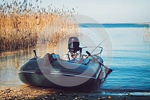 Rubber fishing boat on a tranquil lake shore.