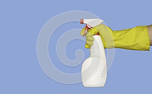 A rubber-gloved hand holds a spray gun with cleaning or disinfectant. Isolated, blue background, free space for text.