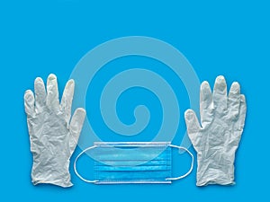 Rubber gloves and medical mask on blue background. The ncov-19 coronavirus pandemic. Anti-virus protection against flu photo