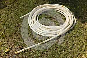 Rubber hose is kept in round shape on the ground.