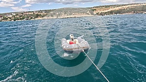 Rubber inflatable dinghy boat been dragged behind a yacht during sailing.