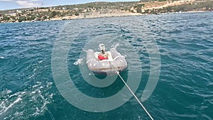 Rubber inflatable dinghy boat been dragged behind a yacht during sailing.