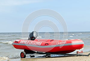 Rubber lifeguard boat trailer on sea shore