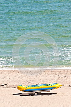 Rubber raft-boat on a trailer on tropical beach, shoreline