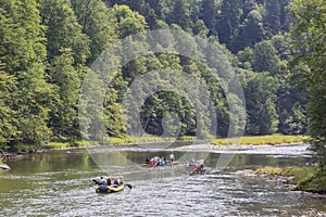 Rubber raft and wooden boats with tourists on the Dunajec river in Szczawnica