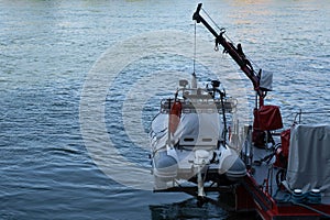 Rubber rescue boat hangs behind a fire brigade fire boat in Basel