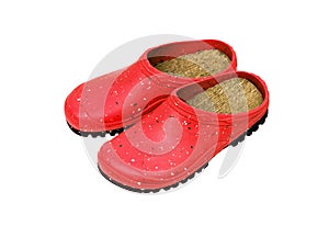 Rubber shoes isolate on a white back. Colored rubber slippers on a tractor sole. Shoes for the garden, beach and housework