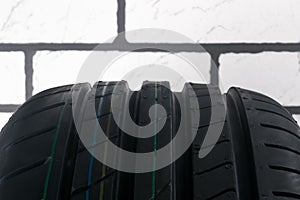 Rubber tires from a car, front view, against a brick wall