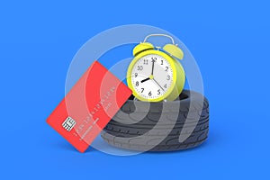 Rubber tyre near credit card and alarm clock. The cost of replacing car wheels