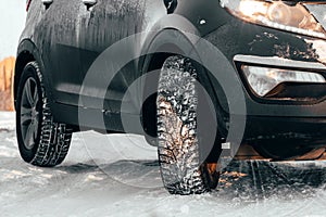 Rubber winter wheels in cold snowy weather on slippery road. Danger of skidding or accidents when driving car close-up