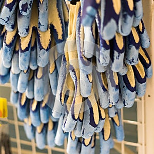 Rubberized grey work gloves hanging on the wall. Part of work-wear and protection equipment.