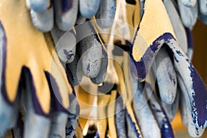 Rubberized grey work gloves hanging on the wall. Part of work-wear and protection equipment.