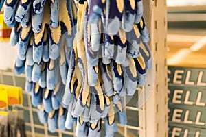 Rubberized grey work gloves hanging on the wall. Part of work-wear and protection equipment.