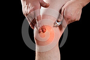 Rubbing medicated ointment into the affected knee photo