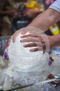 Rubbing quartz crystal ball orb, sphere is believed to eliminate bad vibes and to bring harmonious, calming energy to any space