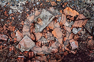 Rubbish from broken red bricks, broken building material, destruction from atmosphere, outdoors. Close-up grunge background