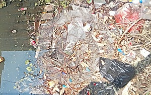rubbish in the city center irrigation: plastic bottle waste, dry leaves, etc. seen in the irrigation, ecosystem pollution