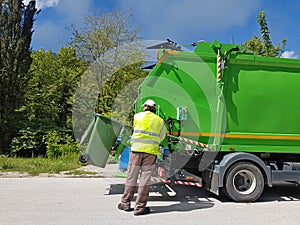 Rubbish cleaner man working green truck
