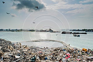 Rubbish dump view full of smoke, litter, plastic bottles,rubbish and trash at the Thilafushi local tropical island