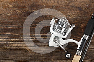 Rubel reel and fishing rod on a wooden background. photo