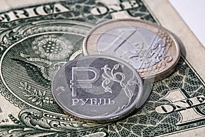 Ruble against the background of euro coins and dollar bills. The concept of exchange rates of currencies