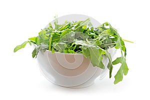 Rucola or arugula, fresh green rocket salad in a white bowl, is