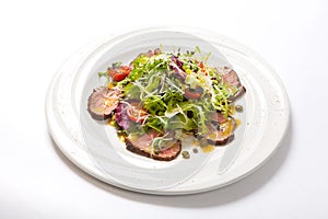 Rucola salad and beaf on a white plate