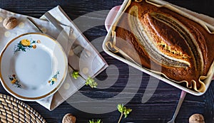 Ruddy banana sponge cake with vintage plate, healthy snack on rustic black table. View from above