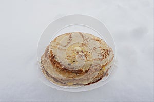 Ruddy Russian pancakes on a plate in winter, pancakes on a plate outside